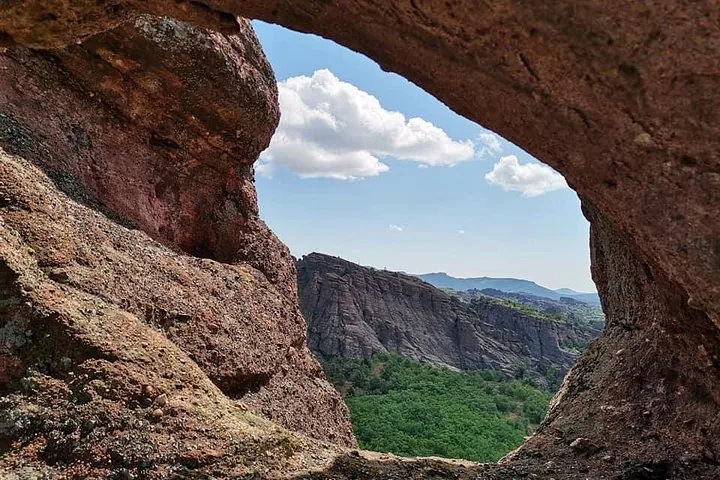 View of rocky landscape through a natural stone arch